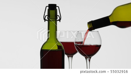 Rose wine. Red wine pour in wine glass over white background 55032916