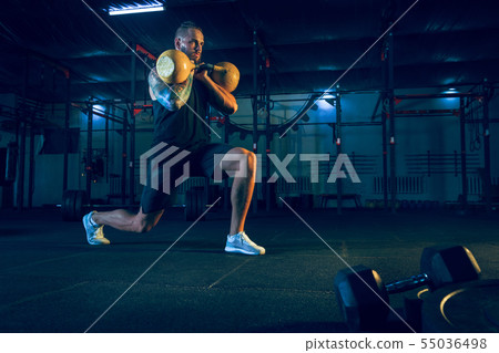 Young healthy man athlete doing exercise in the gym Young healthy man athlete doing exercise in the gym 55036498