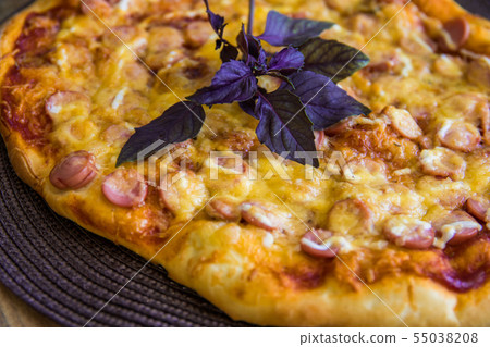 Homemade pizza with salami and mozzarella decorated with basil Homemade pizza with salami and mozzarella decorated with basil 55038208