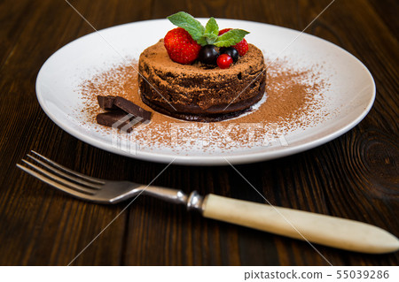 Chocolate fondant lava cake decorated with strawberries and cocoa powder 55039286