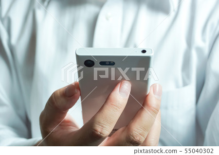 觀看穿襯衣的人的智能手機背景的人 55040302