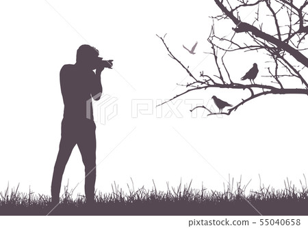 A young man in nature photographing birds sitting 55040658