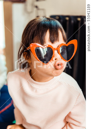 Fashionable little girl with long bangs wearing light sweater Fashionable little girl with long bangs wearing light sweater 55041189