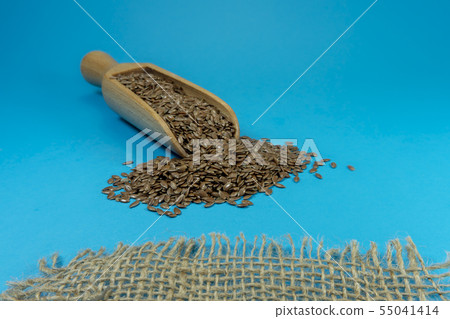 Flax seeds spilling from a wooden scoop 55041414