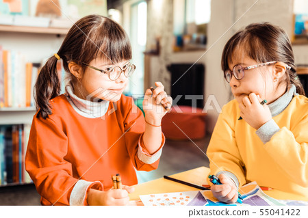 Cute children with down syndrome talking to each other and discussing Cute children with down syndrome talking to each other and discussing 55041422