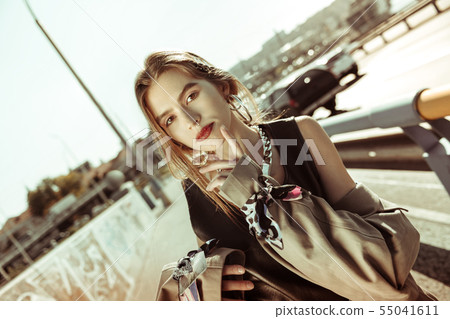 Thoughtful nice-looking girl with red lips wearing oversize coat Thoughtful nice-looking girl with red lips wearing oversize coat 55041611
