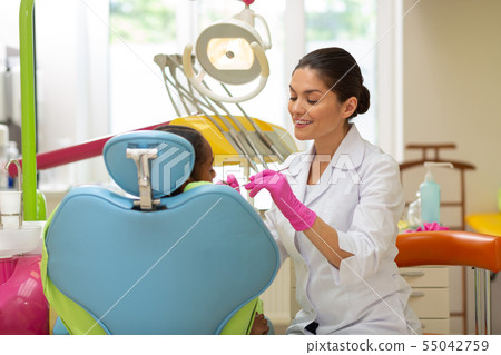 Female doctor examining a young African American girl Female doctor examining a young African American girl 55042759