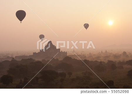 Orange mystical sunrise landscape view with silhouettes of old ancient temples and palm trees in Orange mystical sunrise landscape view with silhouettes of old ancient temples and palm trees in 55052098
