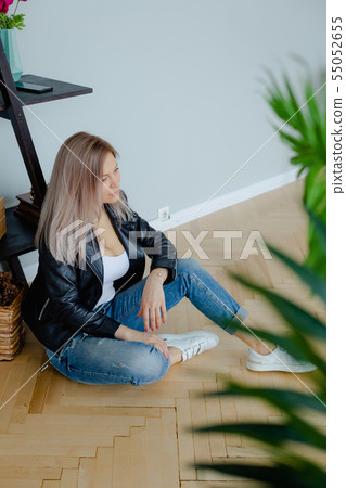 A blonde woman in a black leather jacket is A blonde woman in a black leather jacket is 55052655