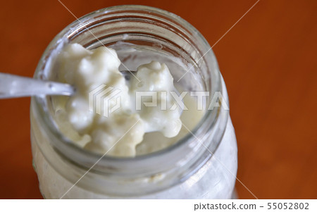 A teaspoon stirs the kefir and raises some 55052802