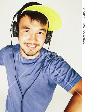 young asian man in hat and headphones listening music on white background young asian man in hat and headphones listening music on white background 55053450