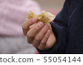 Man's hand holds a bitten pancake.  55054144