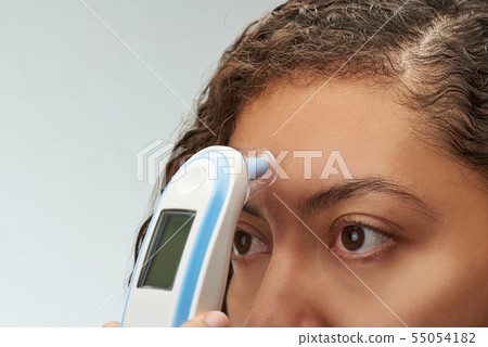 Woman using digital thermometer 55054182