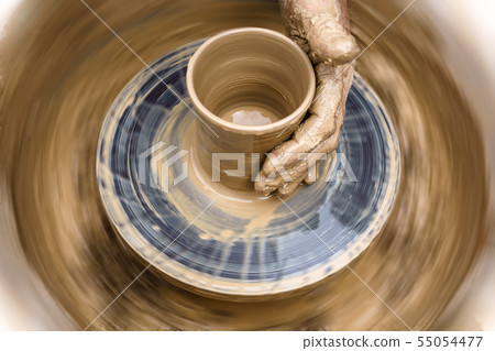 potter's hand mold pottery on a rotating wheel 55054477