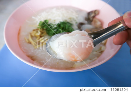 eating rice gruel, rice porridge or congee 55061204