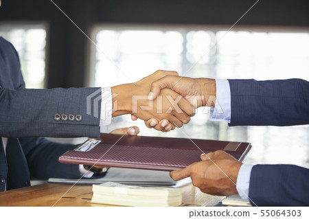 Young business people shaking hands in the office. 55064303