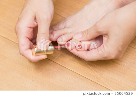 Woman applying a foot manicure 55064529