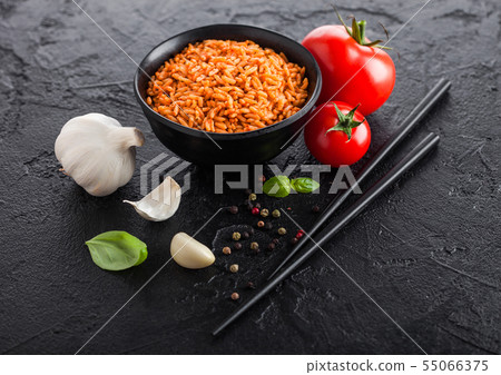Black plate bowl of rice with tomato and basil and 55066375