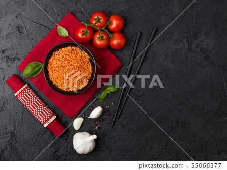 Black plate bowl of rice with tomato and basil and 55066377