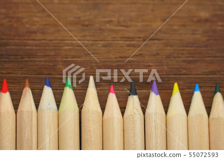 Mix pencil colors array on wood background. Mix pencil colors array on wood background. 55072593