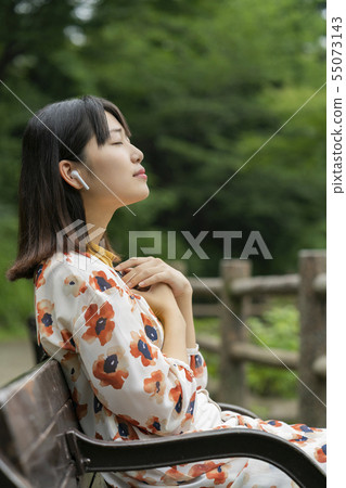 A woman listening to music 55073143