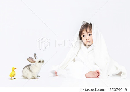 Little baby girl playing with a duck and a rabbit wearing a white bath towel on a white background. Happy, affection, baby, childcare image Little baby girl playing with a duck and a rabbit wearing a white bath towel on a white background. Happy, affection, baby, childcare image 55074049