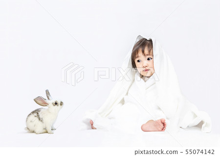 使用與兔子孩子的女嬰穿在白色背景的一塊白色毛巾。快樂，感情，嬰兒，育兒形象 55074142