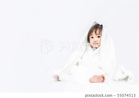 Little baby girl playing with a white bath towel on a white background. Happy, affection, baby, childcare image 55074513
