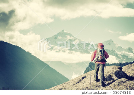 Mountaineer with backpack on rock Mountaineer with backpack on rock 55074518