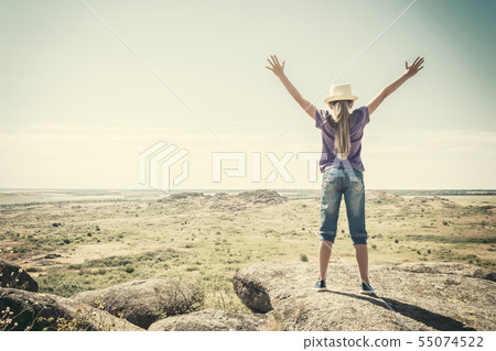 Happy teenage girl at rock with hands up Happy teenage girl at rock with hands up 55074522