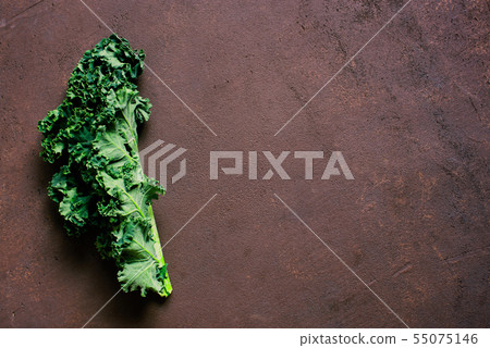 Brown textured background with fresh kale Brown textured background with fresh kale 55075146