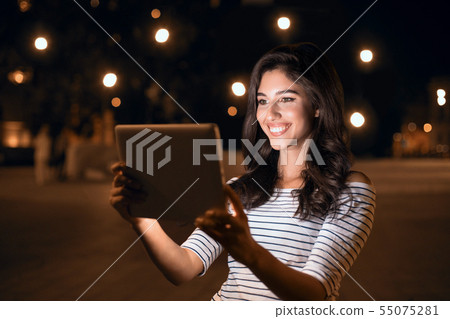 Social networks. Woman surfing internet on tablet in the city 55075281