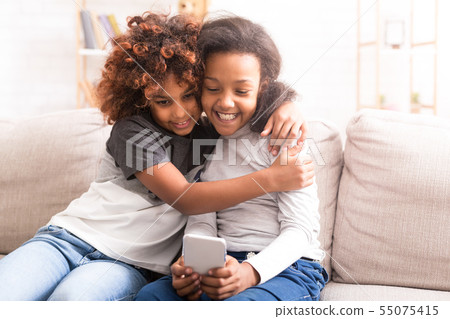 Preteen girls using smartphone, spending time together Preteen girls using smartphone, spending time together 55075415