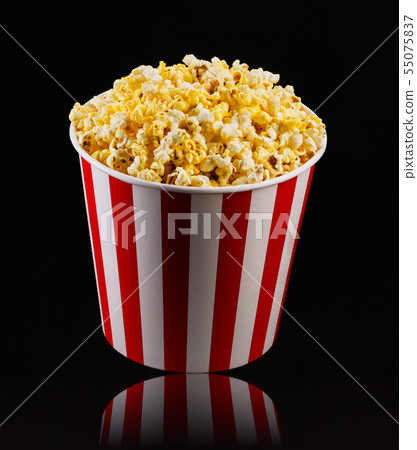 Paper striped bucket with popcorn isolated on black background 55075837