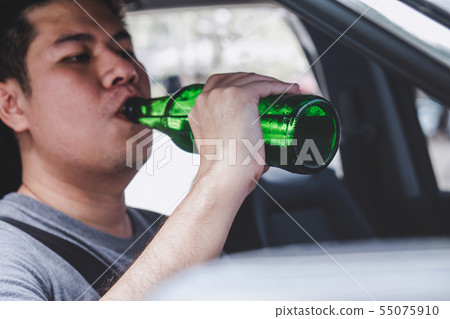 Young asian man drives a car with drunk a bottle 55075910
