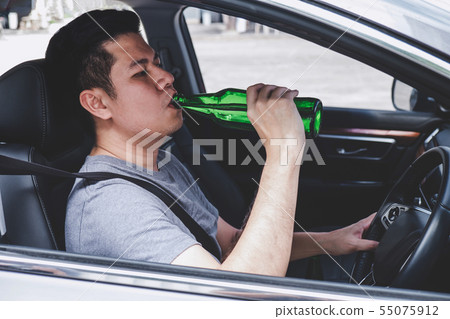 Young asian man drives a car with drunk a bottle 55075912