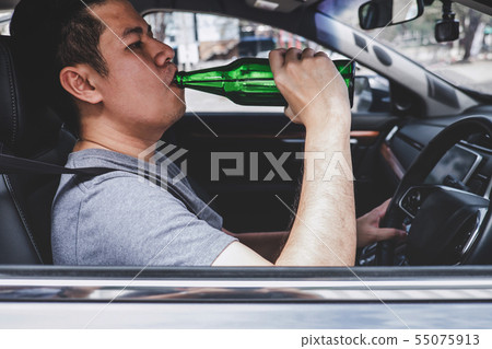 Young asian man drives a car with drunk a bottle 55075913