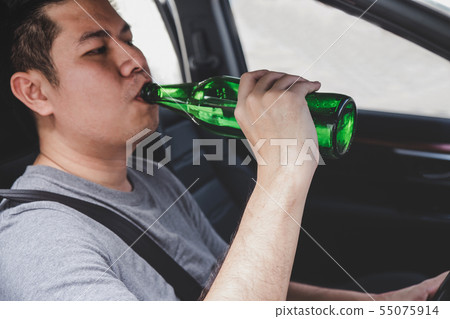 Young asian man drives a car with drunk a bottle 55075914