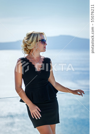 Beautiful woman in dress against the sea Beautiful woman in dress against the sea 55076211