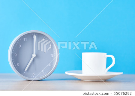 alarm clock and coffee cup on blue background alarm clock and coffee cup on blue background 55076292