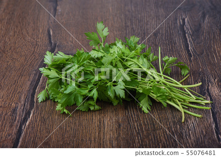 Fresh parsley leaves on wooden table. Rustic style. Fresh parsley leaves on wooden table. Rustic style. 55076481