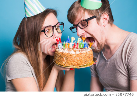 Close up of bizarre young couple girl and boy in paper hats want to bite off a piece of 55077746
