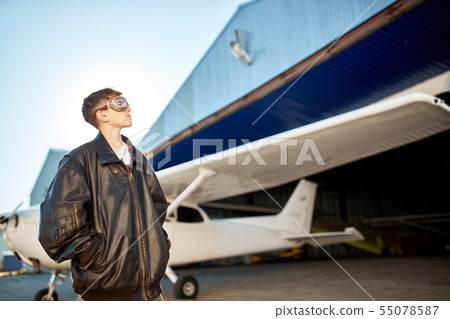 boy looking thoughtfully, thinking about first flight, dressed in large pilot jacket boy looking thoughtfully, thinking about first flight, dressed in large pilot jacket 55078587