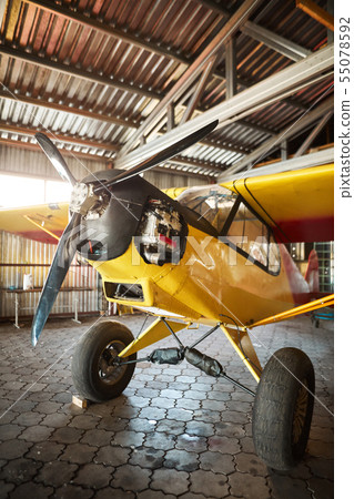 light private plane standing in aircraft shed, ready for repair and service works 55078592