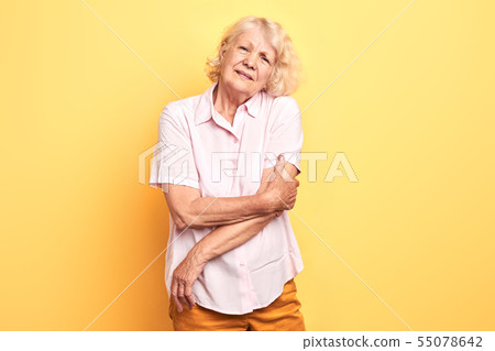 elderly beautiful woman touches her arm elderly beautiful woman touches her arm 55078642