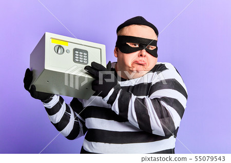 fat thief shugging his shoulder while holding a safe in hands 55079543