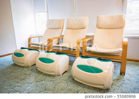 Three empty foot massage chairs in a spa cabinet Three empty foot massage chairs in a spa cabinet 55080906