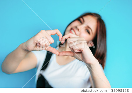 Happy carefree girl with dark long hair on blue Happy carefree girl with dark long hair on blue 55098138