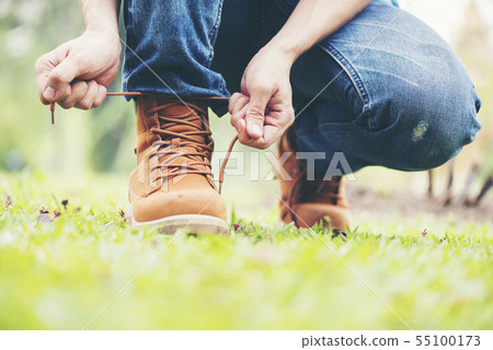 Footwear concept.Handsome man wear jeans knelt Footwear concept.Handsome man wear jeans knelt 55100173