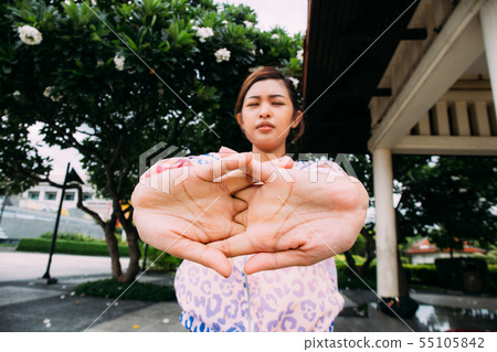 Asian sportswoman stretching arms with closed eyes Asian sportswoman stretching arms with closed eyes 55105842